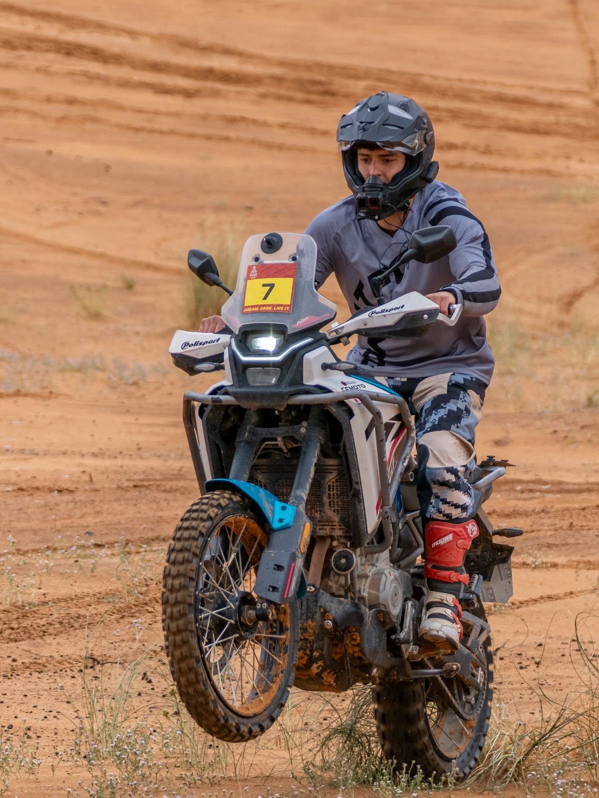 Piloto levantando la rueda delantera en el desierto